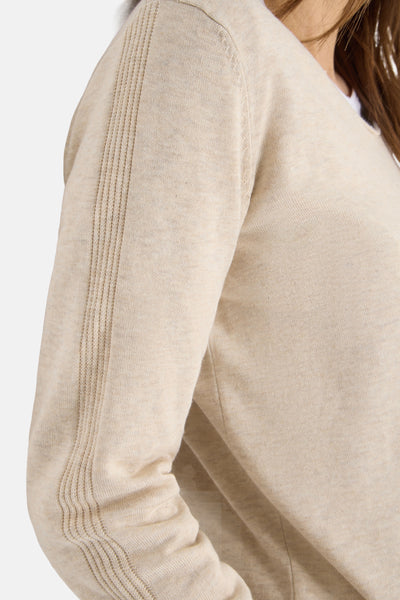 Pull à col en V beige de CECIL, avec un détail de maille côtelée sur la manche.