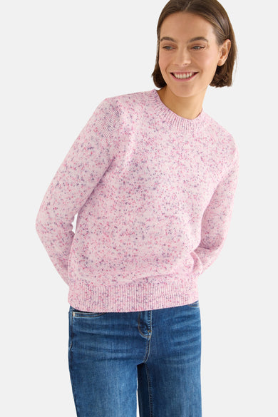 Ronde hals trui roze van CECIL, gedragen met een wijde pijpen spijkerbroek en een bruine tas.