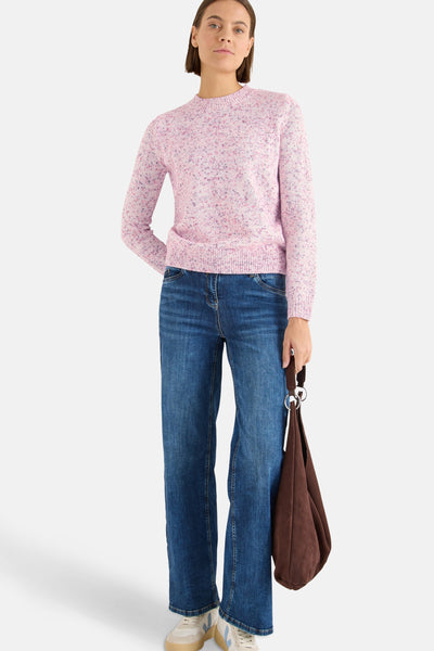 Pull à col rond rose de CECIL, porté avec un jean bleu à jambes larges et un sac marron.