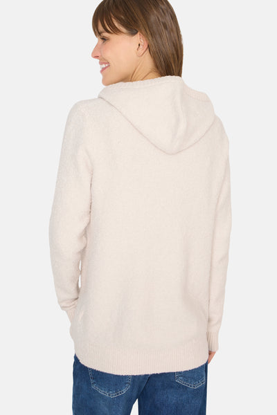 Pull à capuche écru de CECIL, avec capuche et tricot texturé, porté avec un jean bleu.
