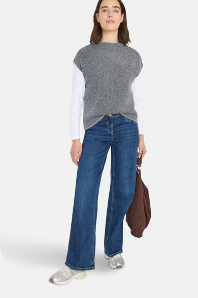 Débardeur gris chiné de CECIL, porté sur un t-shirt blanc à manches longues et un jean bleu ample.