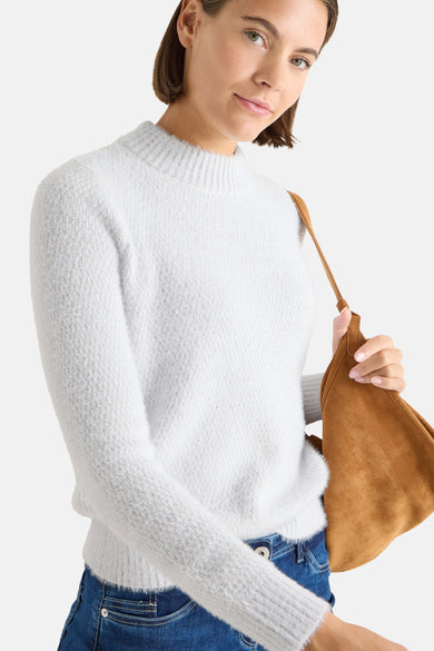 Pull col montant gris de CECIL, porté avec un jean bleu et un sac en daim marron.