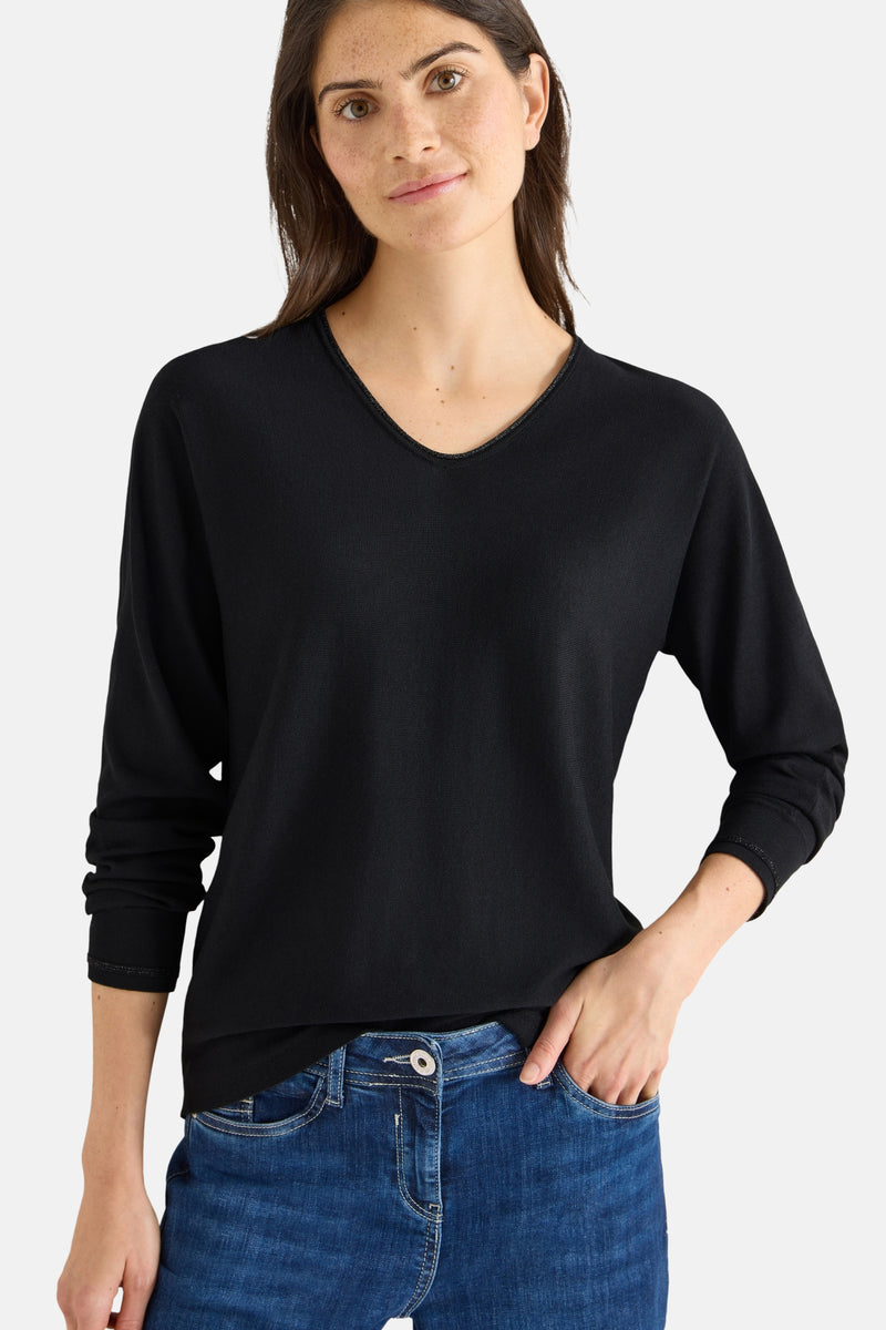 Pull noir à col rond de CECIL, porté avec un jean bleu.
