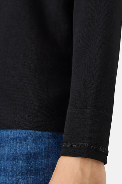 Pull ras du cou noir de CECIL, en tricot fin, porté avec un jean bleu.