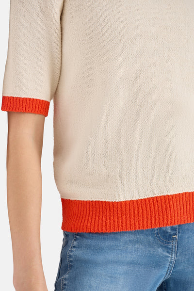 Beige trui met ronde hals van CECIL, korte mouwen met feloranje bies, gedragen met een blauwe jeans.
