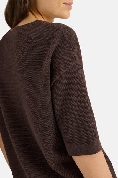 Brown textured knit sweater with three-quarter sleeves, side view showing ribbed hem and round neckline.