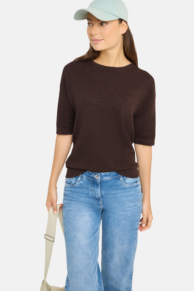 Brown textured short-sleeve crewneck sweater by Pull, worn with light blue jeans and mint cap, front view.