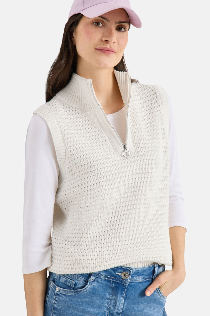 Wit gebreid vest van CECIL, gedragen over een top met driekwartmouwen en een casual spijkerbroek.