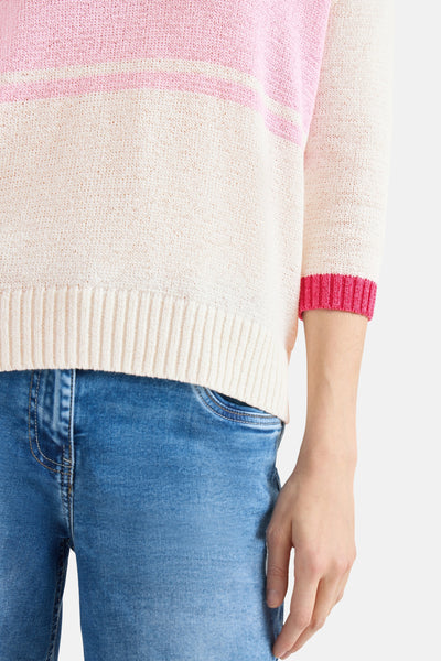 Multikleurige CECIL trui, roze en gebroken witte strepen, gedragen met een blauwe jeans.