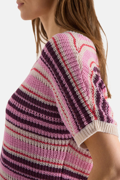 Multicolored knitted sweater with pink, purple, and cream stripes, side view showing textured crochet pattern and ribbed sleeve cuff