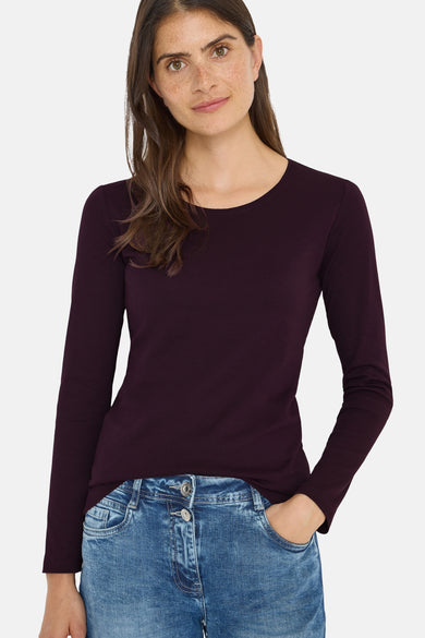 T-shirt à manches longues mauve de CECIL, porté avec un jean bleu et une main dans la poche.
