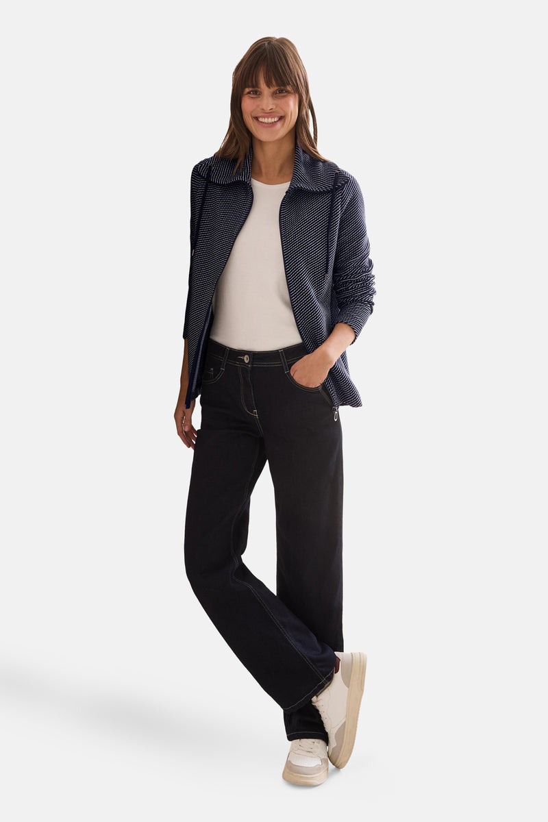 Sweat-gilet bleu de CECIL porté avec un T-shirt blanc et un jean foncé.