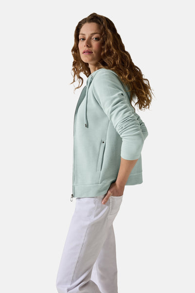 Blauwe jas van CECIL, met kap en knopsluiter, gedragen met een witte broek, zijkant.