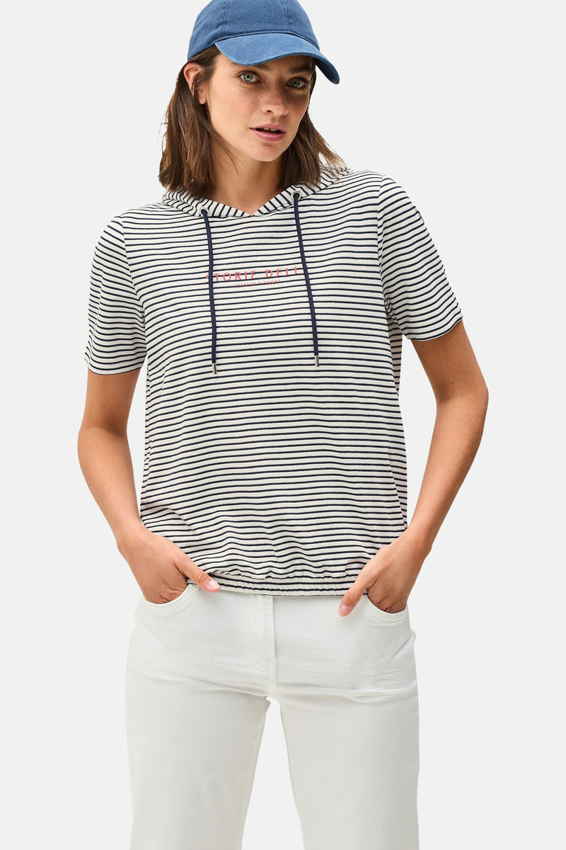 Multikleur gestreept T-shirt met korte mouwen van CECIL, met capuchon en trekkoord, gedragen met een witte broek en een blauwe pet.