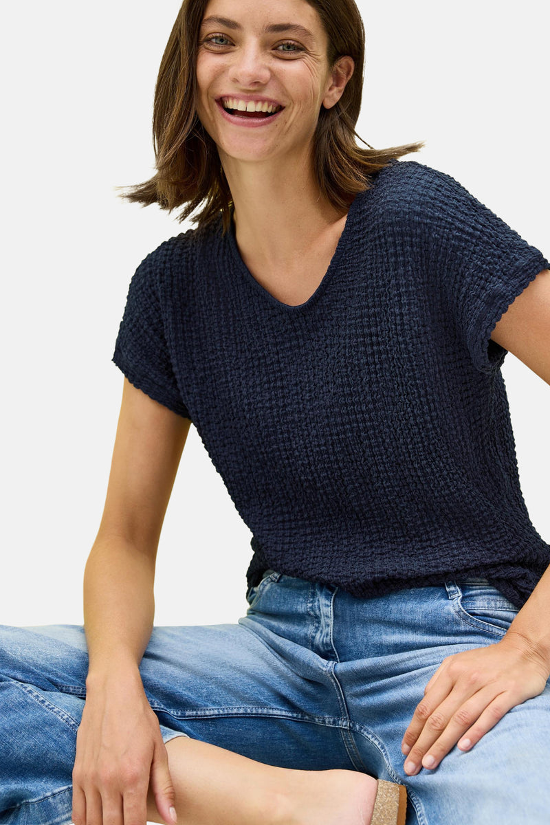 Blauw T-shirt met korte mouwen van CECIL, in gewafelde textuurstof, gedragen met een spijkerbroek.