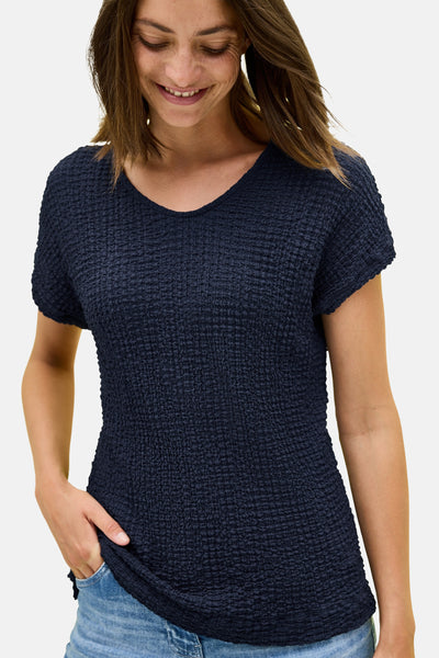 T-shirt bleu texturé à manches courtes de CECIL, porté avec un jean, modèle souriant.
