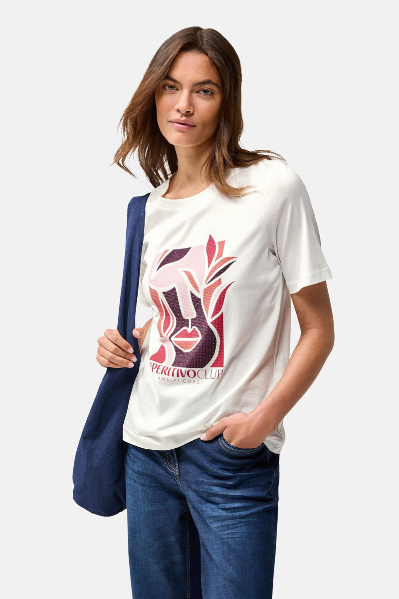 Wit T-shirt met korte mouwen van CECIL met een gestileerde grafische print, gedragen met een spijkerbroek en een blauwe tas.