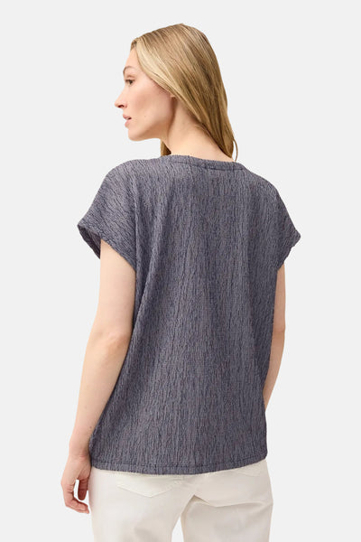 Blouse met korte mouwen in blauwe textuur van CECIL, van achteren gezien, gedragen met een witte broek.