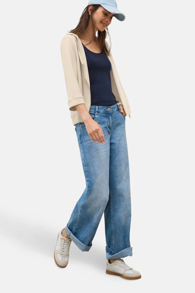 Beige vest van CECIL, gedragen over een marineblauwe tanktop en een opgerolde wijde jeans.