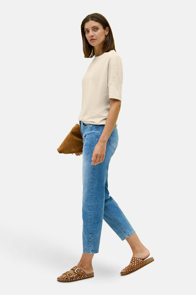 Beige T-shirt met korte mouwen van CECIL, gedragen met een spijkerbroek en bruine sandalen.