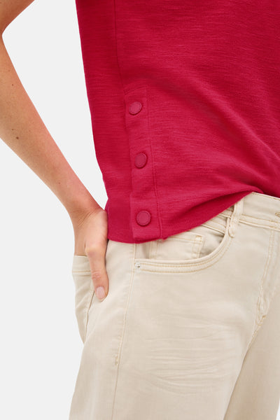 T-shirt rouge à manches courtes de CECIL, avec boutons décoratifs sur le côté et porté avec un pantalon beige.