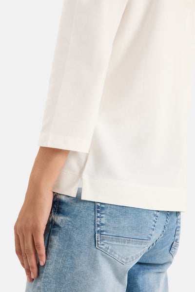 Ecru T-shirt met lange mouwen van CECIL, gedragen met een lichtblauwe jeans, zijaanzicht.