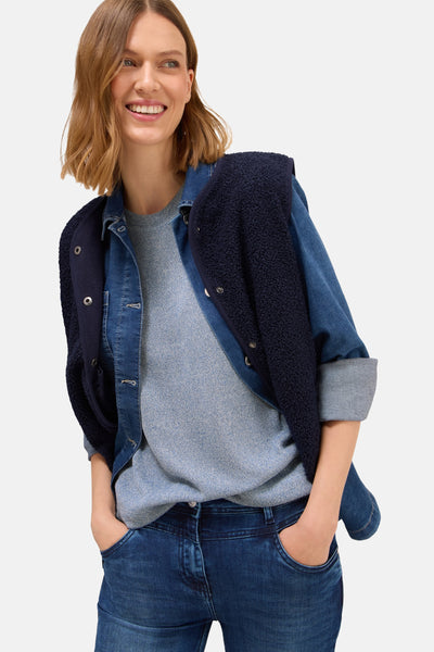 Ronde hals trui blauw van CECIL, gedragen met een spijkerjasje en een lamswollen vest.