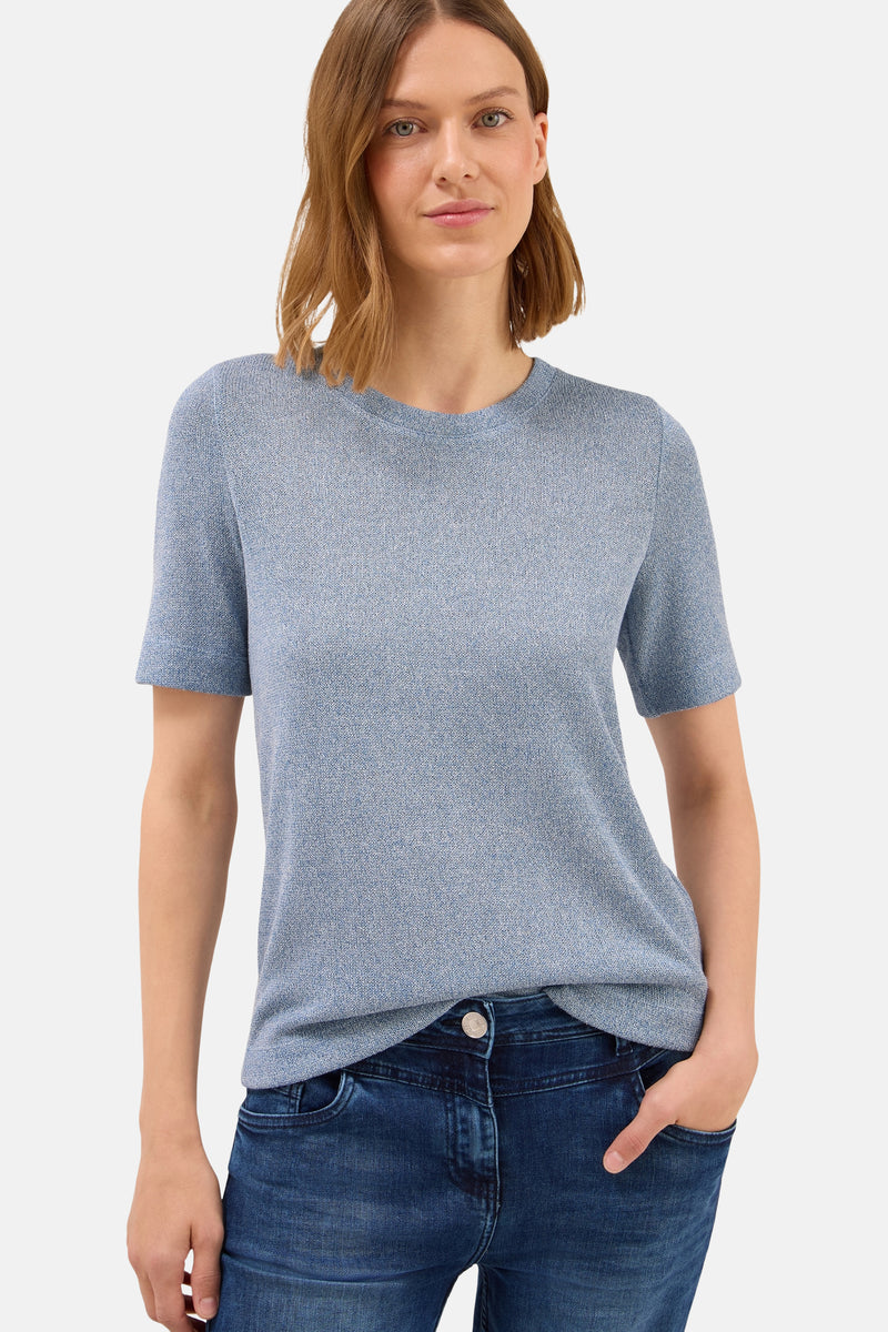 Ronde hals trui blauw van CECIL, gedragen met een donkerblauwe jeans, handen in de zakken.