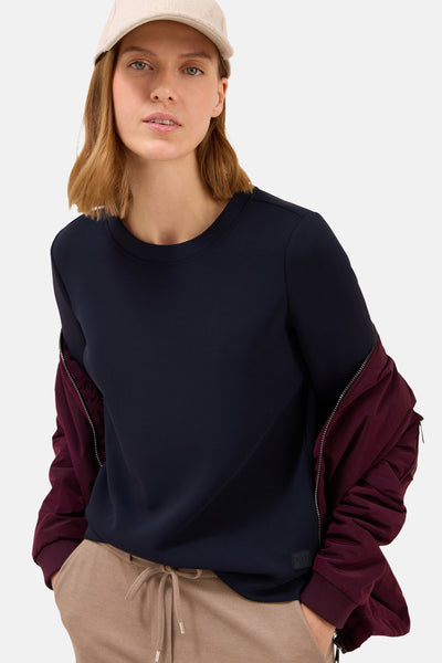 Blauw T-shirt met korte mouwen van CECIL, gedragen met een bordeauxrode jas en een beige broek.