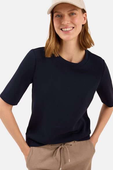 Blauw T-shirt met korte mouwen van CECIL, gedragen met een bruine broek met trekkoord, beige pet.