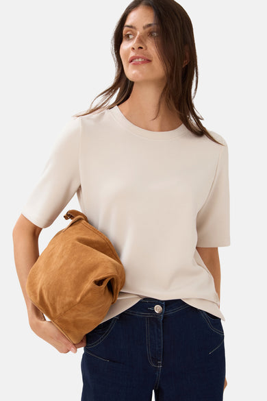 Top met korte mouwen beige van CECIL, gedragen met een donkerblauwe jeans en een bruine suède tas.