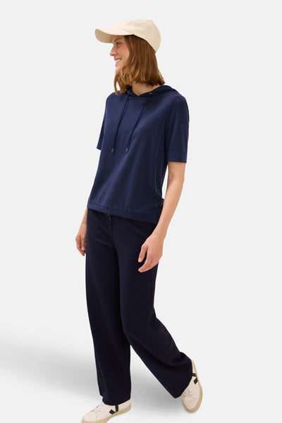 Sweat à capuche bleu de CECIL, porté avec un pantalon assorti, un chapeau beige et des baskets blanches.