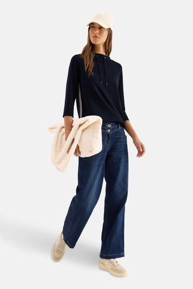 Blauwe hoodie van CECIL met driekwartmouwen, gedragen met een wijde jeans en een beige pet.