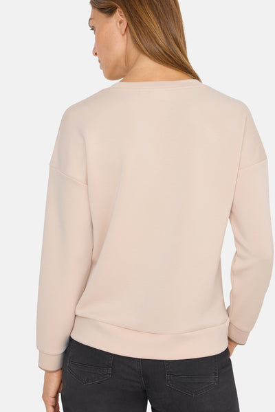 Beige ronde hals sweatshirt van CECIL, achterkant, met geribbelde zoom en manchetten, gedragen met een zwarte broek.