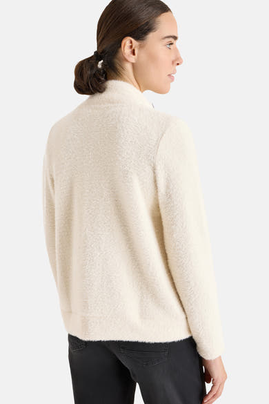 Ecru cardigan in fluffy knit from CECIL, worn with black trousers, back view.