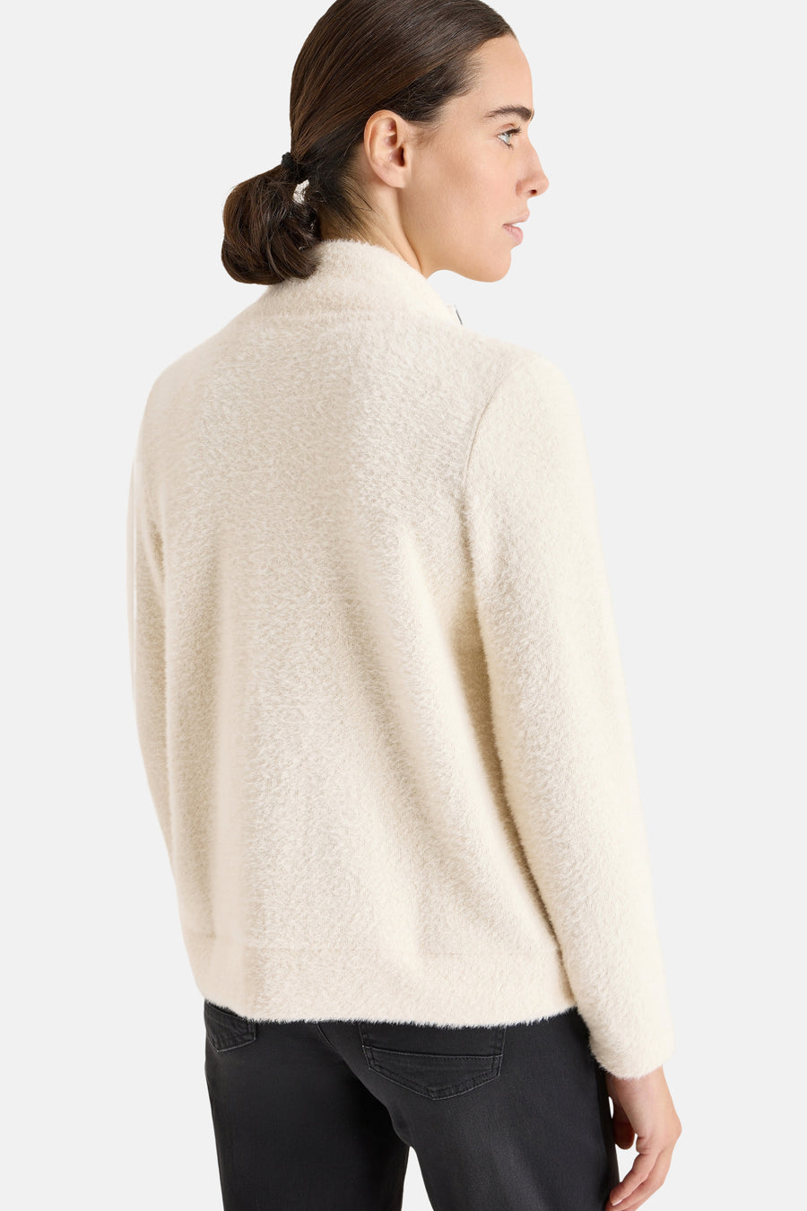 Ecru cardigan in fluffy knit from CECIL, worn with black trousers, back view.