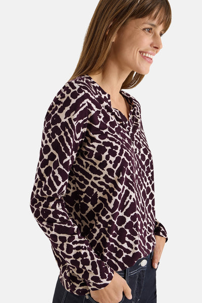 Lila T-shirt met lange mouwen van CECIL, met wit abstract patroon, gedragen met een blauwe jeans.