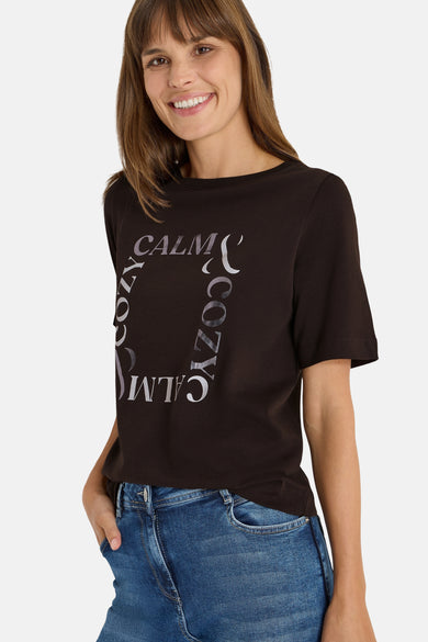 Bruin T-shirt met korte mouwen van CECIL, met grafische print "calm, cozy" en gedragen met een blauwe jeans.