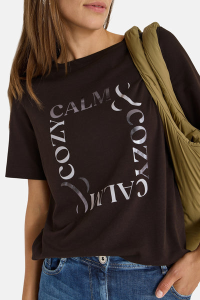 Bruin T-shirt met korte mouwen van CECIL, met een decoratieve print 'Cozy & Calm', gedragen met een kaki tas.