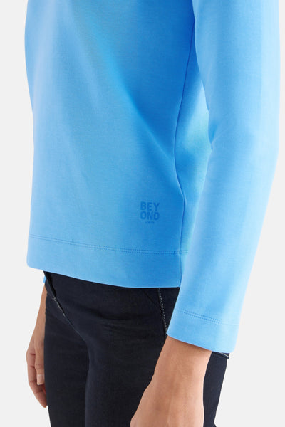 T-shirt bleu de CECIL, manches longues avec le logo imprimé sur le côté, porté avec un pantalon en jean noir.