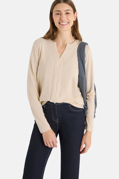 Beige blouse met lange mouwen van CECIL, gedragen met een donkerblauwe jeans en een grijze tas.