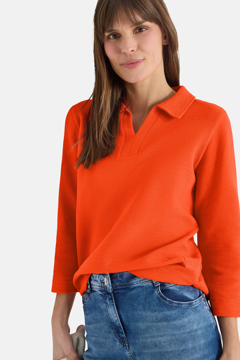 Oranje poloshirt met lange mouwen van CECIL, met driekwartmouwen en gedragen met een blauwe jeans.
