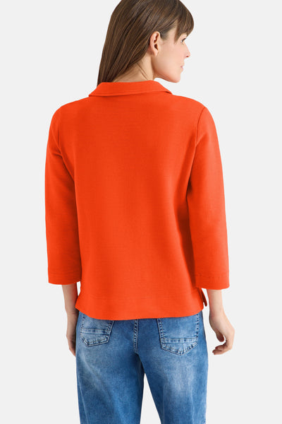 Oranje polo met lange mouwen van CECIL, getextureerd, gedragen met een blauwe spijkerbroek, achterzicht.