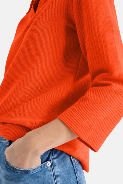Oranje poloshirt met lange mouwen van CECIL, geribbelde textuur, gedragen met een blauwe spijkerbroek.
