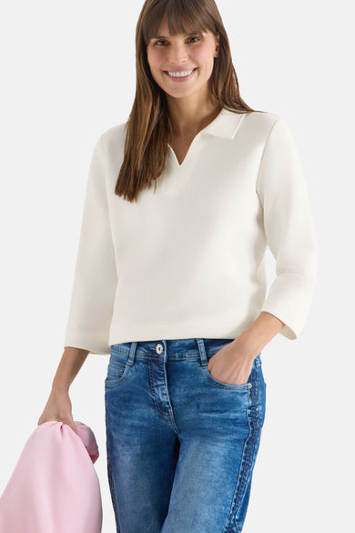 Wit poloshirt met lange mouwen van CECIL, gedragen met een blauwe spijkerbroek en een roze vest.