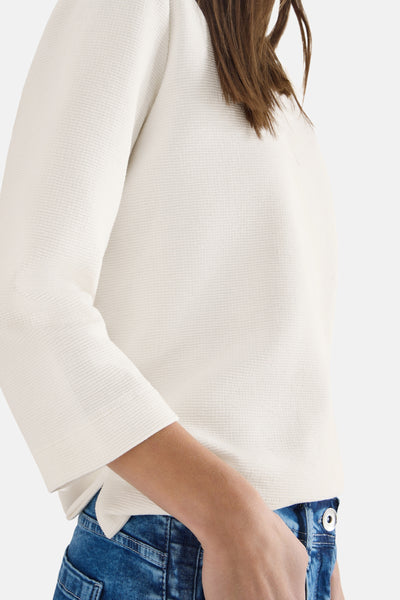 Wit poloshirt met lange mouwen van CECIL, in getextureerd wafelbreisel, gedragen met een blauwe jeans.