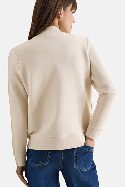 Beige CECIL vest met ribtextuur, lange mouwen en gedragen met een donkerblauwe jeans.
