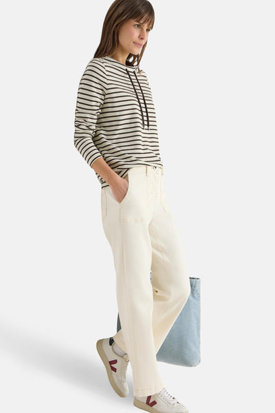 T-shirt à manches longues multicolore de CECIL, rayures horizontales, porté avec un pantalon blanc cassé et des baskets.

