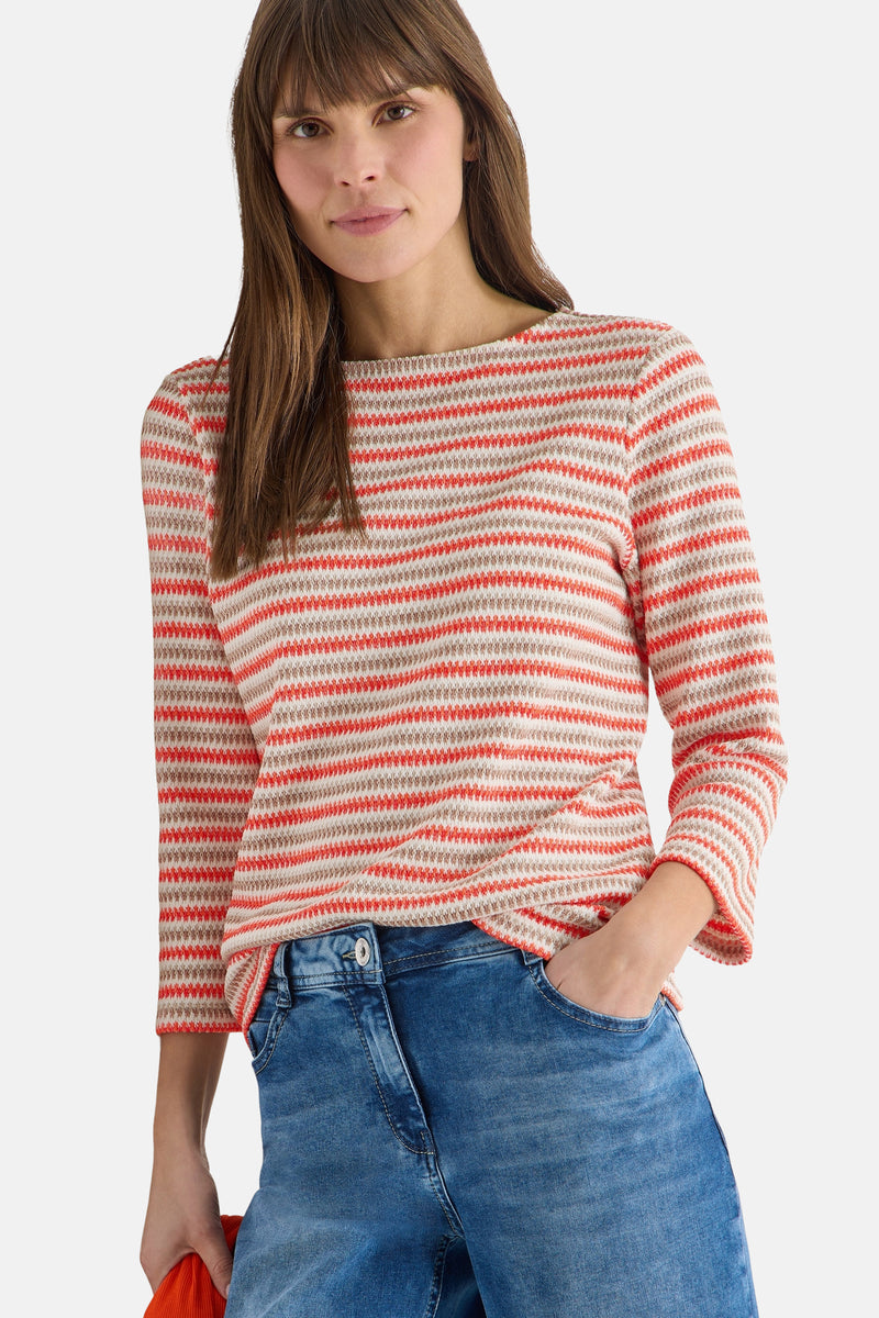Multikleurig T-shirt met lange mouwen van CECIL, met oranje en beige horizontale strepen, gedragen met een spijkerbroek.