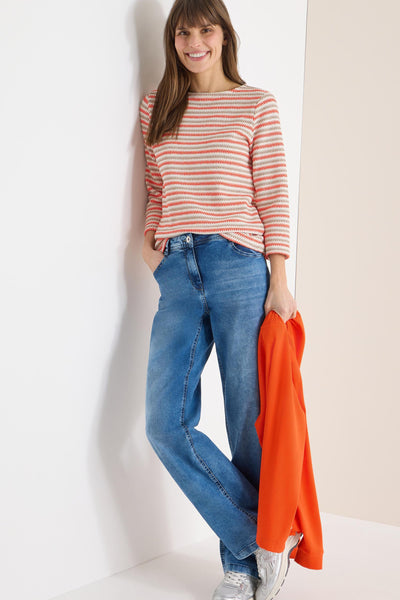 Multikleurig T-shirt met lange mouwen van CECIL, horizontale strepen, gedragen met een blauwe jeans en zilveren schoenen.